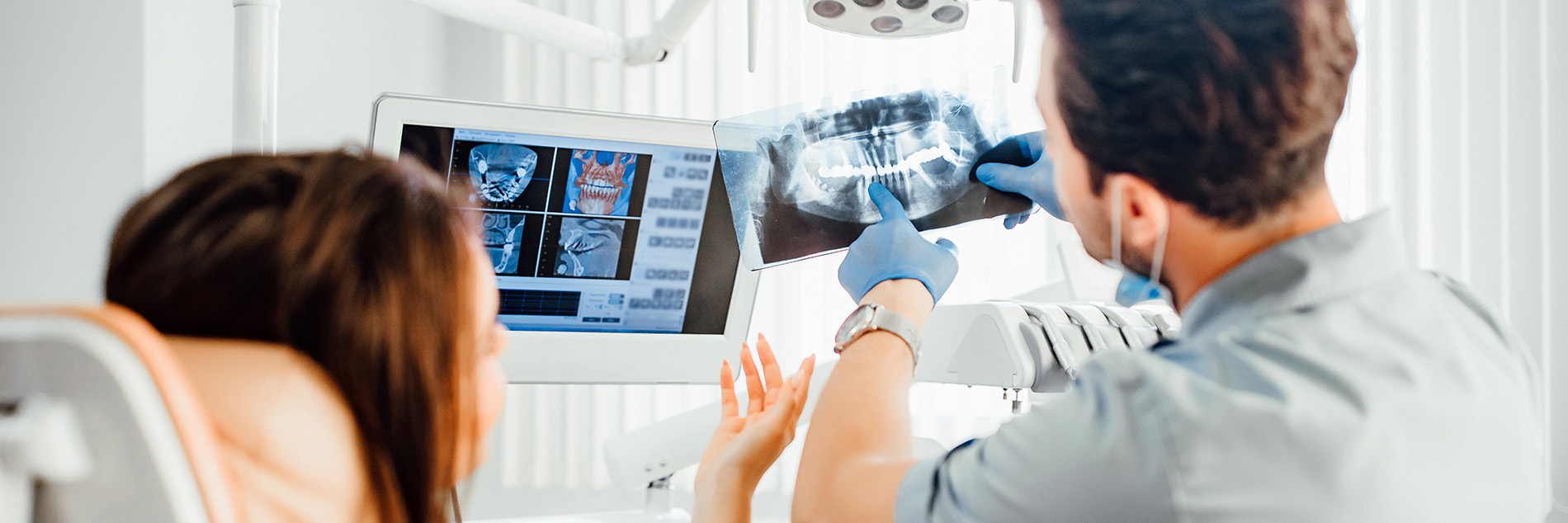 A medical professional in a hospital setting, showing an image of a patient s scan to a seated patient.