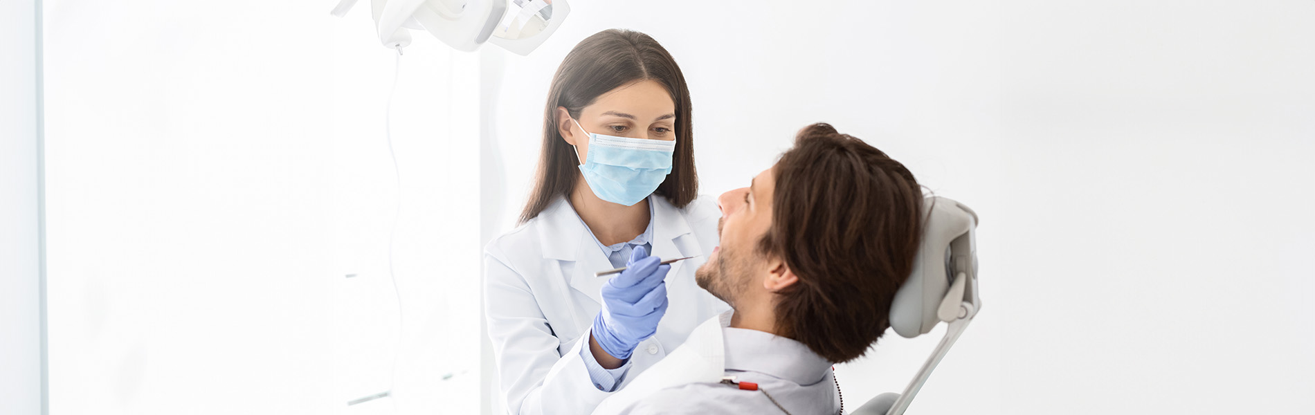 A dental professional assisting a patient during an oral examination.