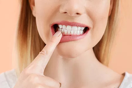 A woman with a toothbrush in her mouth, brushing her teeth.